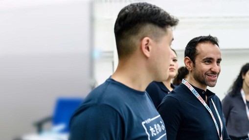 Banner image promoting the TransformTech program. It contains a human and touching a robotic hand.